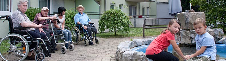 Betreuer mit Senioren und Kinder im Garten